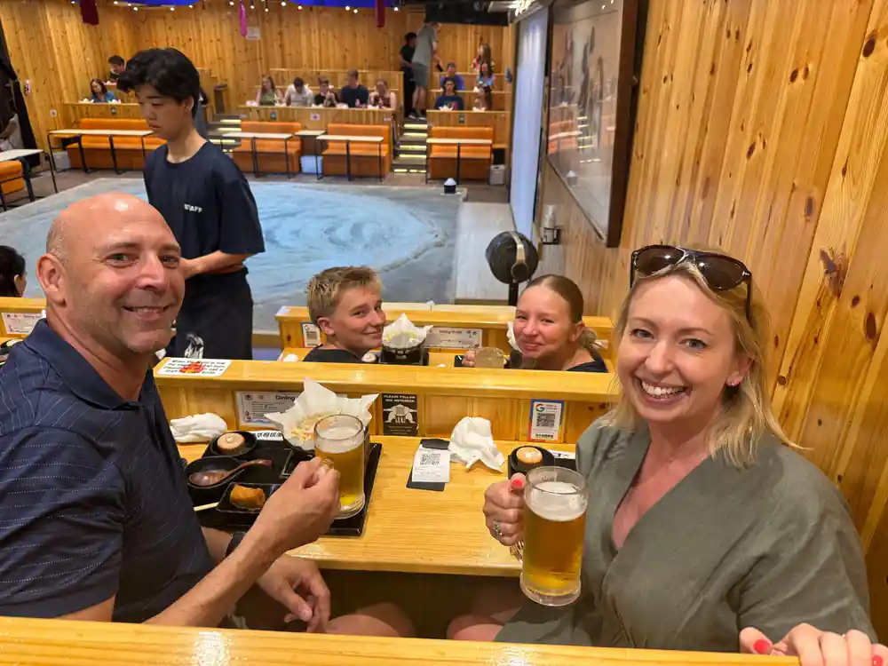 Family dining at wooden table with beverages and food