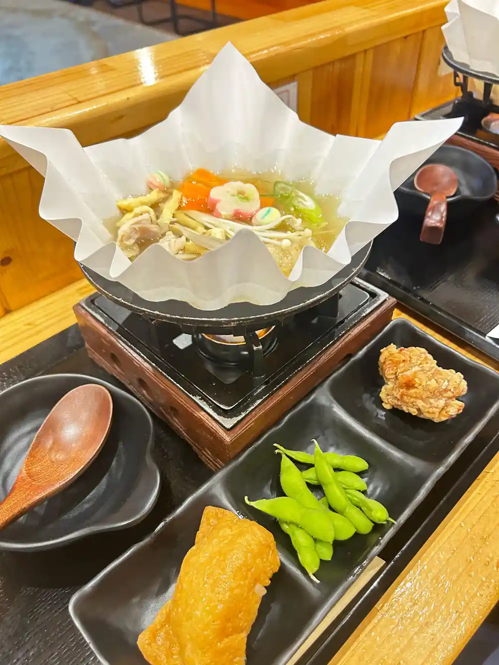 Japanese dish with vegetables and protein on heated plate