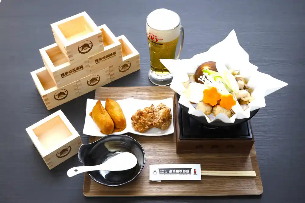 Japanese food platter with wooden boxes and beer glass