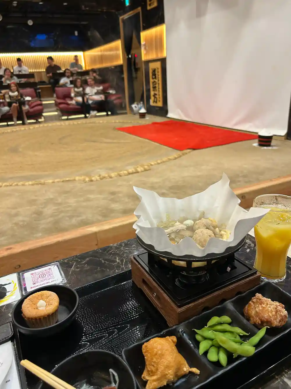 Japanese food tray with appetizers and sumo ring visible