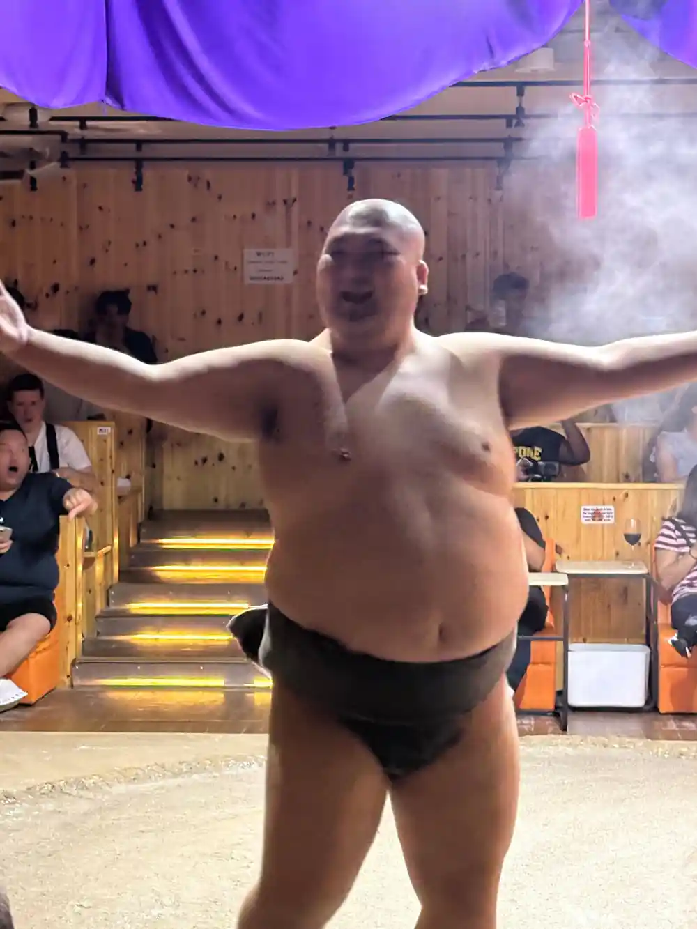 Sumo wrestler posing shirtless in performance arena