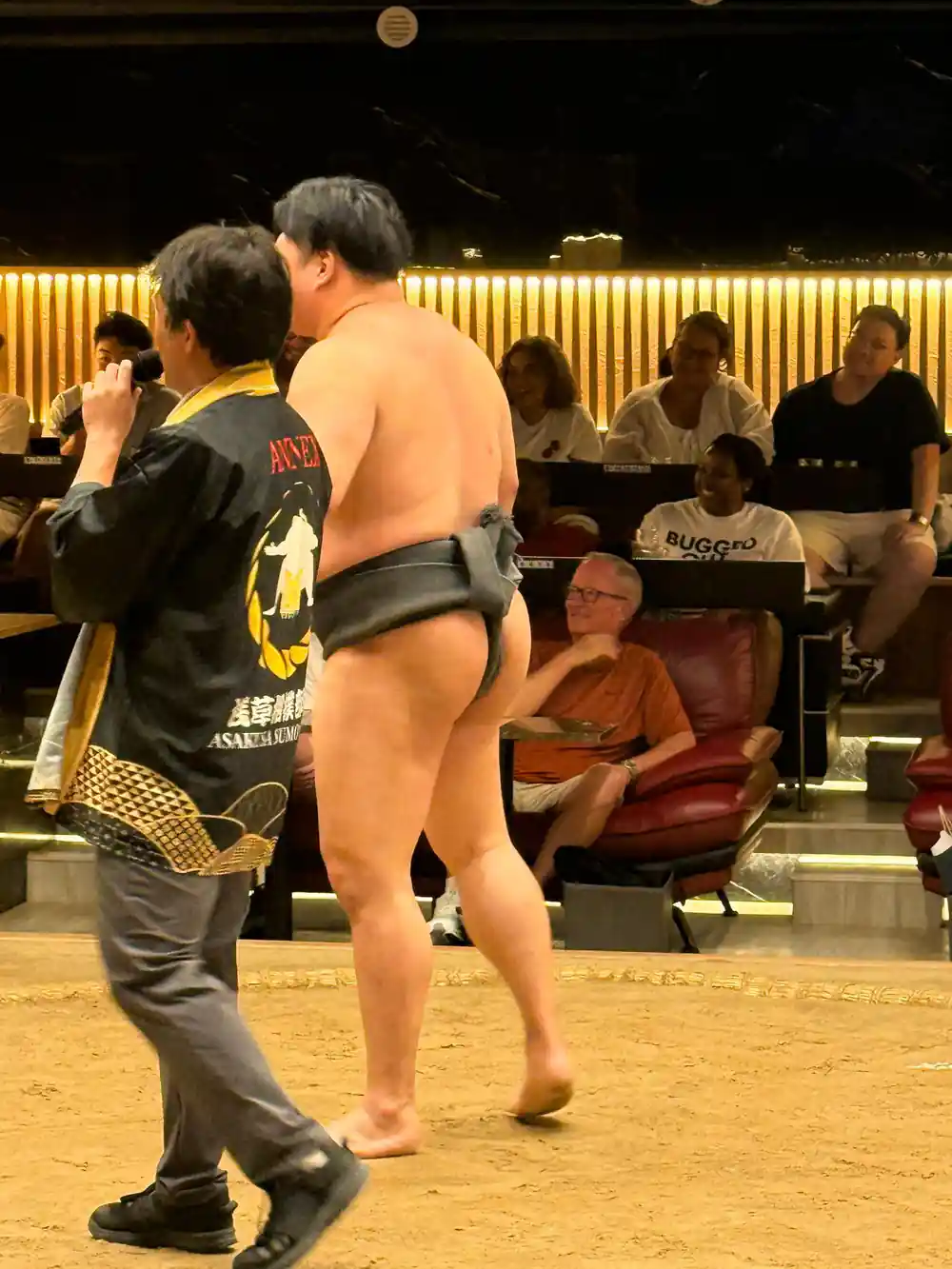 Sumo wrestler talking with official at tournament