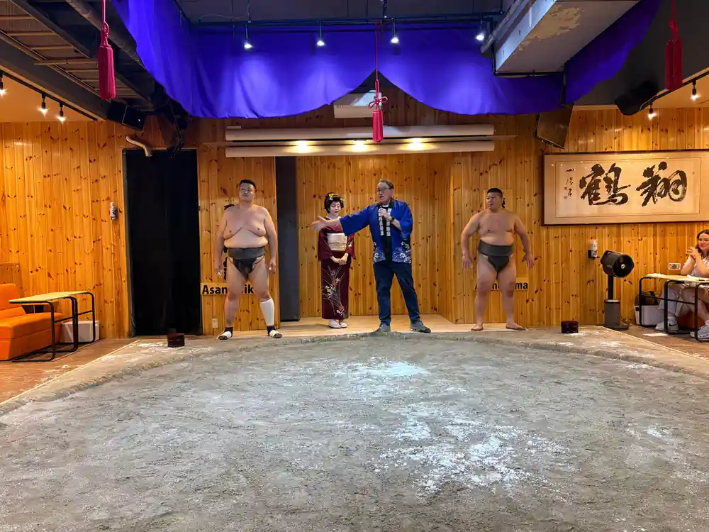 Sumo wrestlers standing in traditional dohyo ring