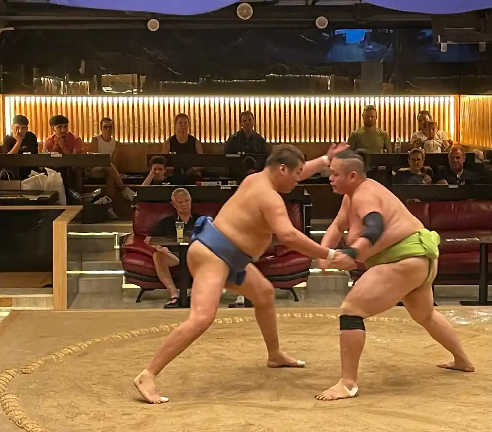 Two sumo wrestlers grappling in arena during bout
