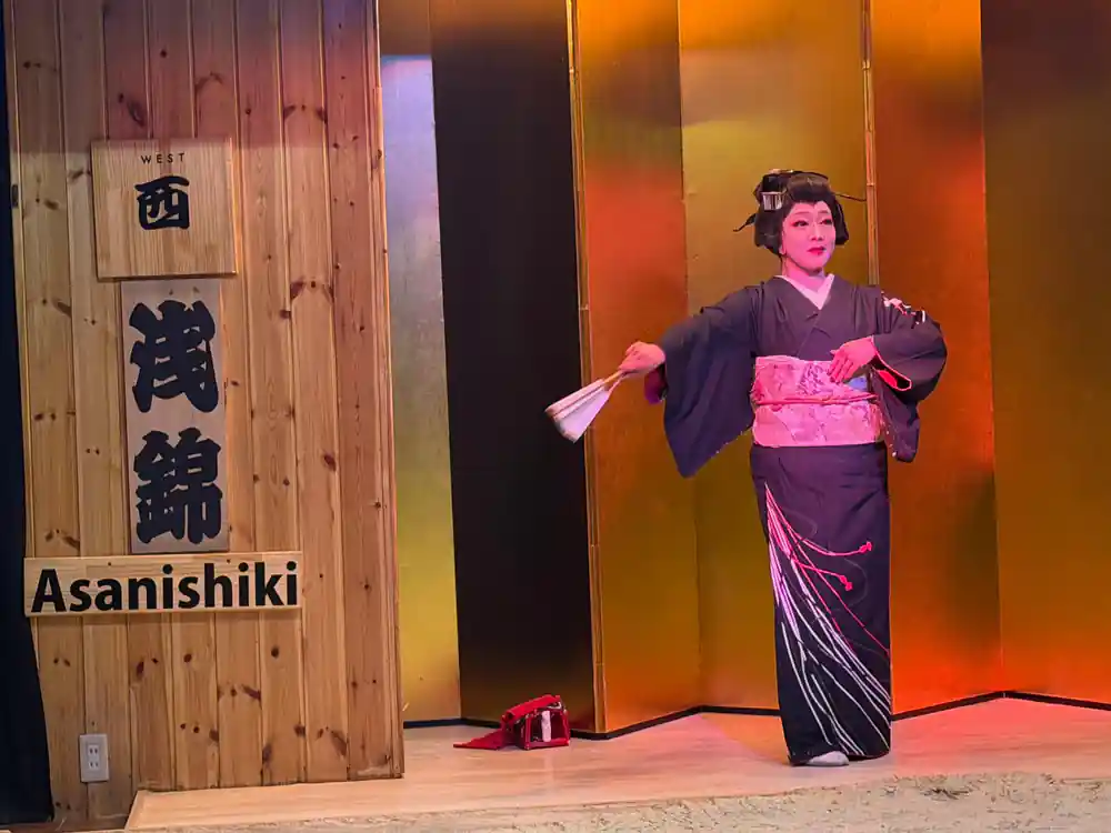 Woman in purple and pink kimono performing with fan
