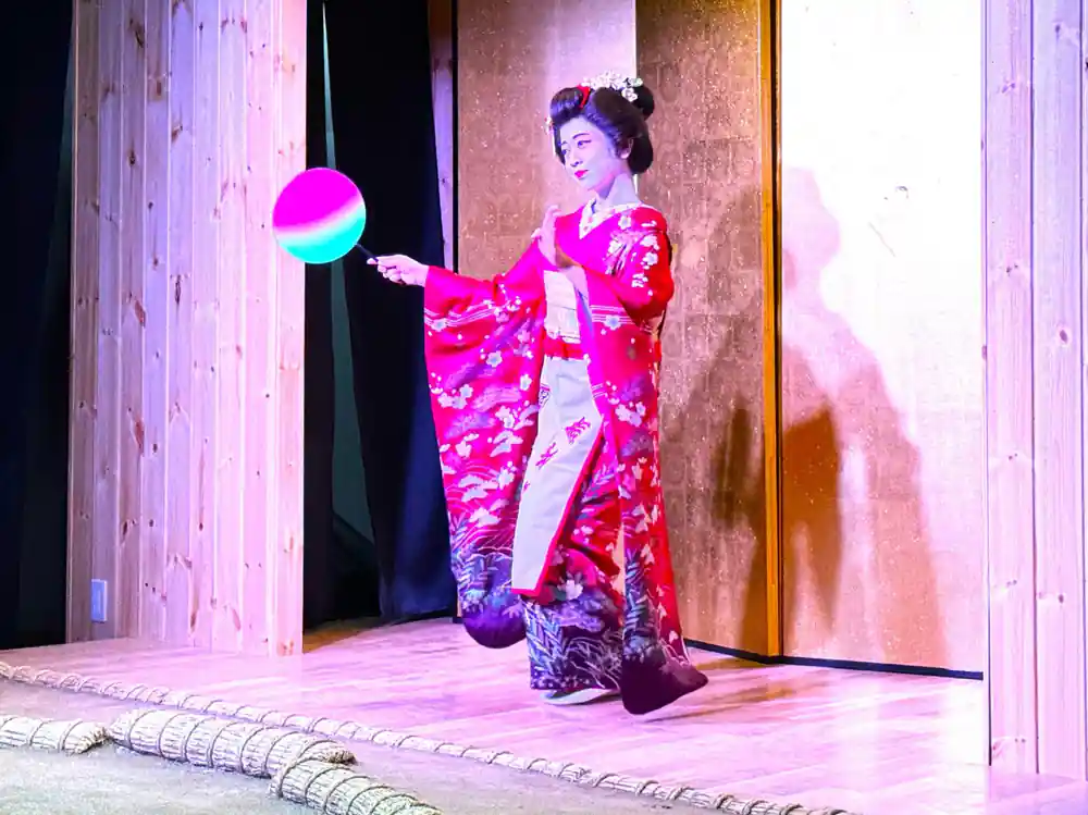 Woman in traditional kimono performing with glowing prop