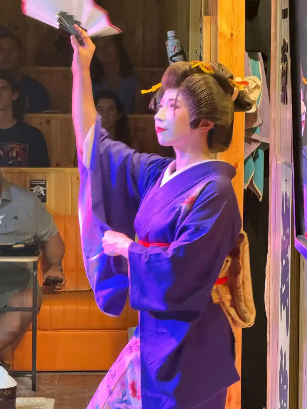 Woman in traditional kimono with raised axe indoors